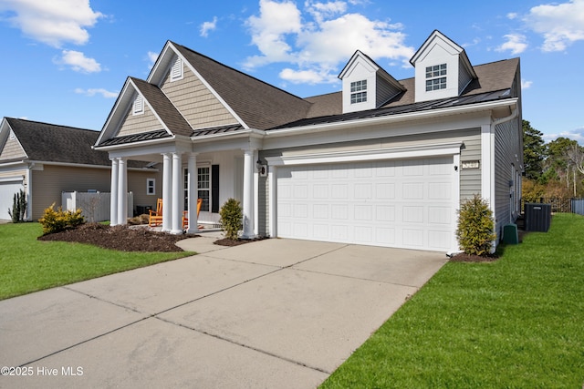 view of front of property featuring driveway, metal roof, an attached garage, a standing seam roof, and a front lawn