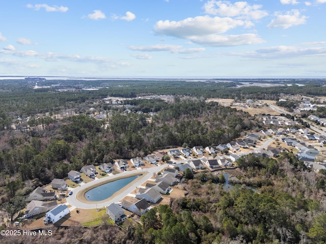 bird's eye view with a wooded view