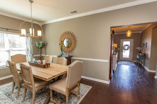 dining room featuring ornamental molding, dark hardwood / wood-style flooring, and a notable chandelier