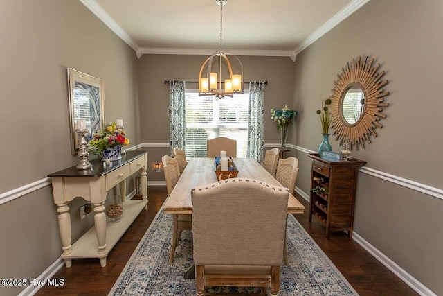 dining room featuring dark wood-type flooring, crown molding, and a chandelier