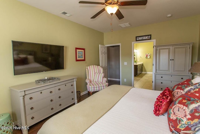 tiled bedroom featuring ceiling fan and ensuite bathroom