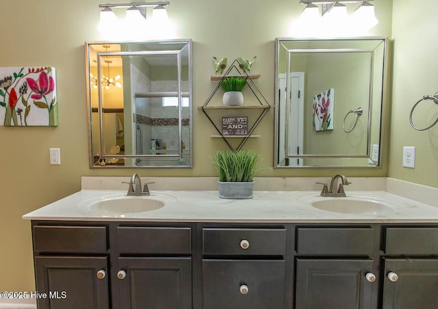 bathroom featuring a shower with door and vanity