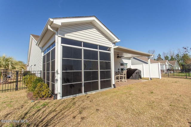 back of property with a patio, a sunroom, ceiling fan, and a lawn