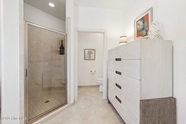 full bath with tile patterned floors, a shower stall, and toilet