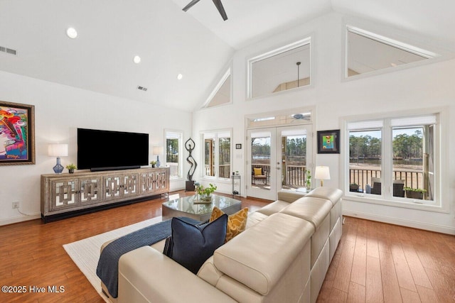 living room featuring baseboards, ceiling fan, french doors, wood finished floors, and high vaulted ceiling