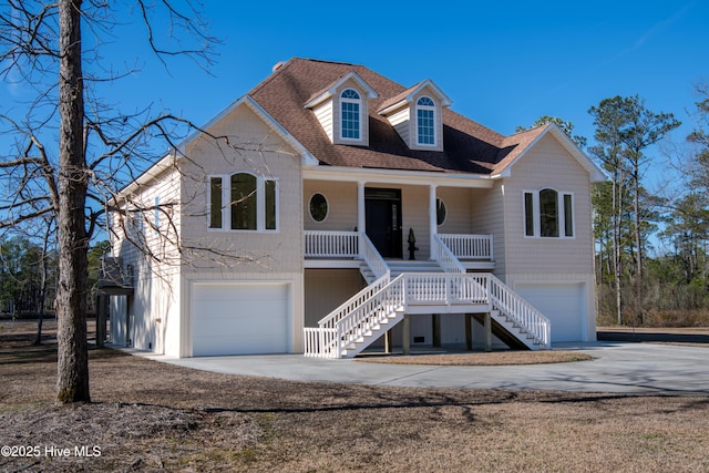 view of front of home with stairway, an attached garage, covered porch, and driveway