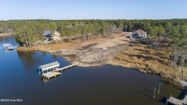 birds eye view of property featuring a wooded view and a water view