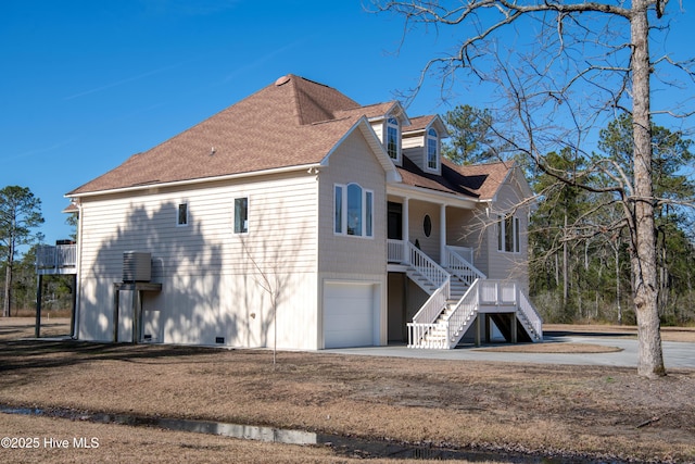 view of property exterior featuring stairway, a garage, and roof with shingles