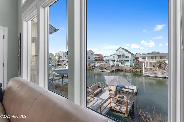 interior space with a residential view, floor to ceiling windows, and a water view