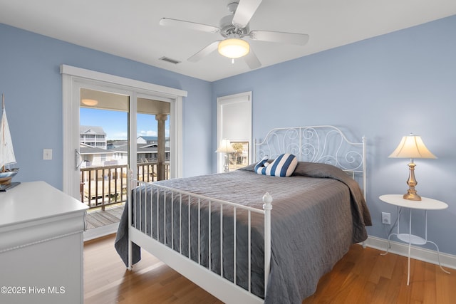 bedroom with access to exterior, visible vents, ceiling fan, wood finished floors, and baseboards