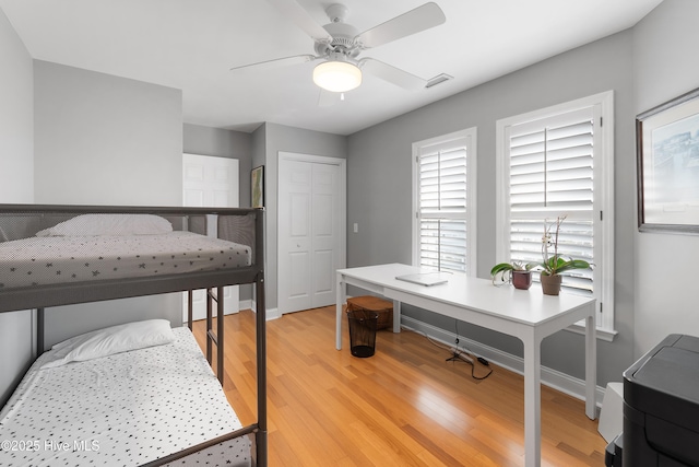 bedroom with a ceiling fan, visible vents, baseboards, a closet, and light wood-type flooring