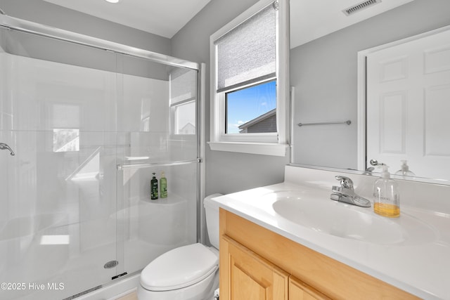 full bathroom featuring toilet, a stall shower, visible vents, and vanity