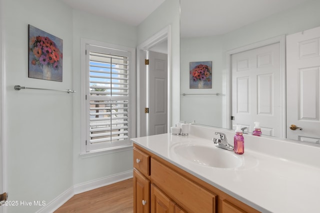 bathroom with vanity, baseboards, and wood finished floors