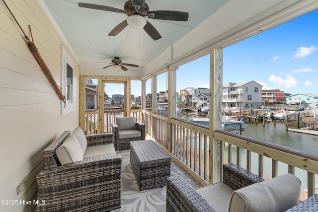 sunroom with a residential view and a water view