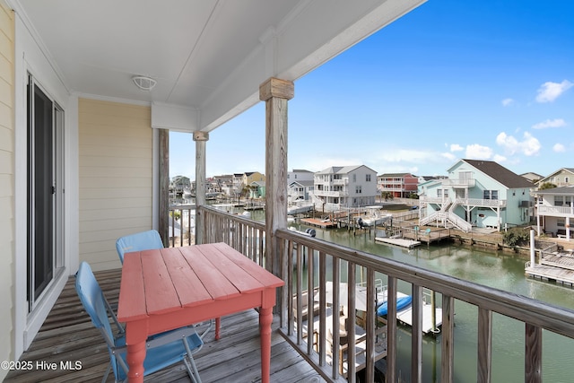 balcony with a residential view and a water view