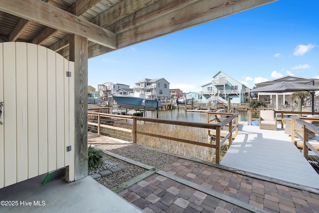 dock area featuring a water view, boat lift, and a residential view