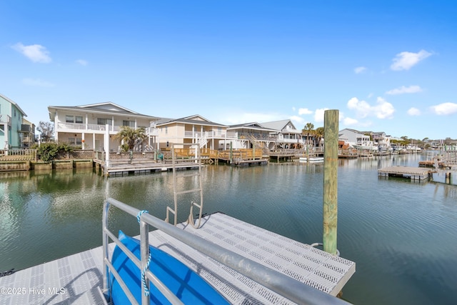 view of dock with a residential view and a water view