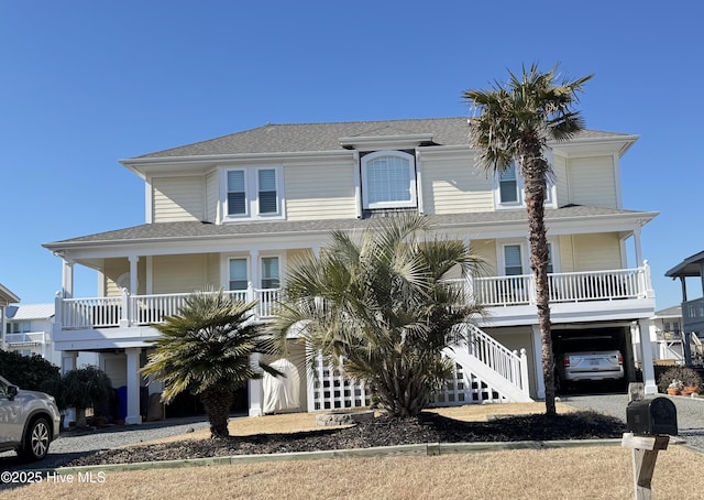 coastal inspired home with covered porch, a carport, stairway, and driveway