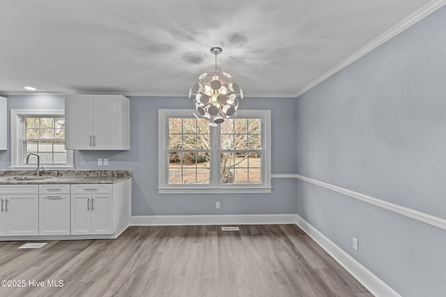 2131 Neuse Cliffs Cir, New Bern, NC 28560 - unfurnished dining area featuring a sink, a chandelier, light wood-style floors, baseboards, and ornamental molding