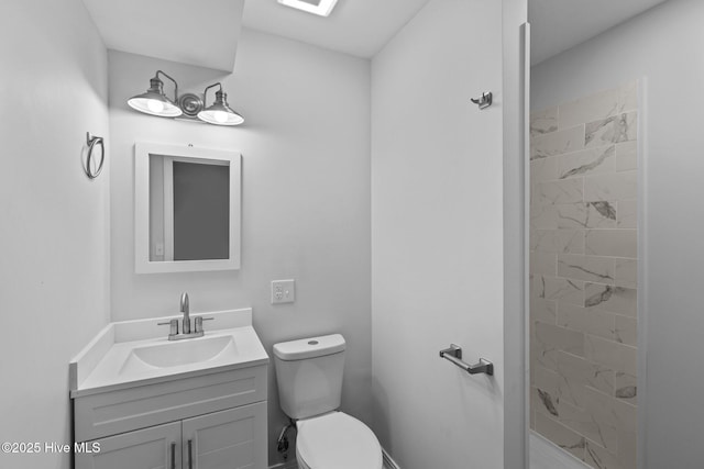 bathroom with vanity, toilet, and a tile shower