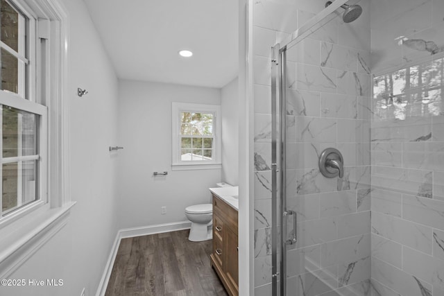 bathroom featuring vanity, hardwood / wood-style floors, toilet, and walk in shower