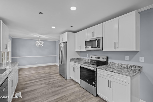 kitchen featuring white cabinets, a chandelier, light stone counters, stainless steel appliances, and light hardwood / wood-style flooring