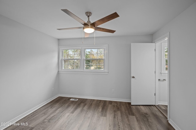 empty room featuring ceiling fan and dark hardwood / wood-style flooring