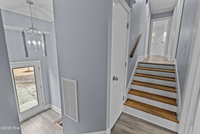 staircase featuring a notable chandelier and hardwood / wood-style flooring