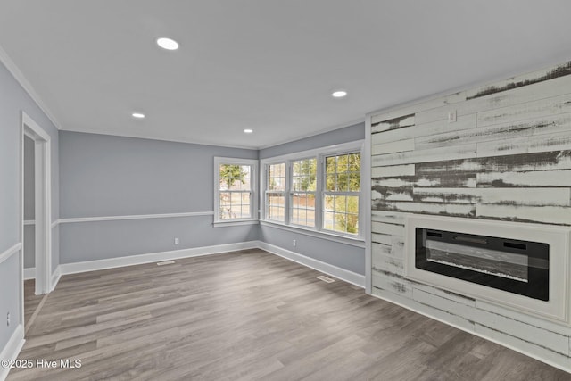 2131 Neuse Cliffs Cir, New Bern, NC 28560 - unfurnished living room with baseboards, wood finished floors, recessed lighting, crown molding, and a glass covered fireplace