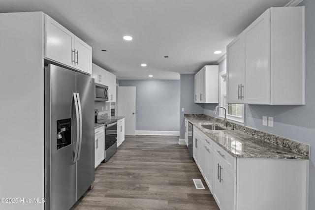 kitchen featuring white cabinetry, sink, stainless steel appliances, and light stone countertops