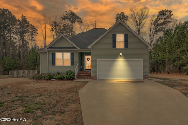 view of front facade with a garage, concrete driveway, and fence