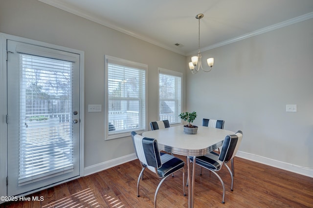 dining space with ornamental molding, dark hardwood / wood-style floors, and a chandelier