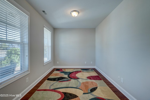 unfurnished room with dark wood-type flooring