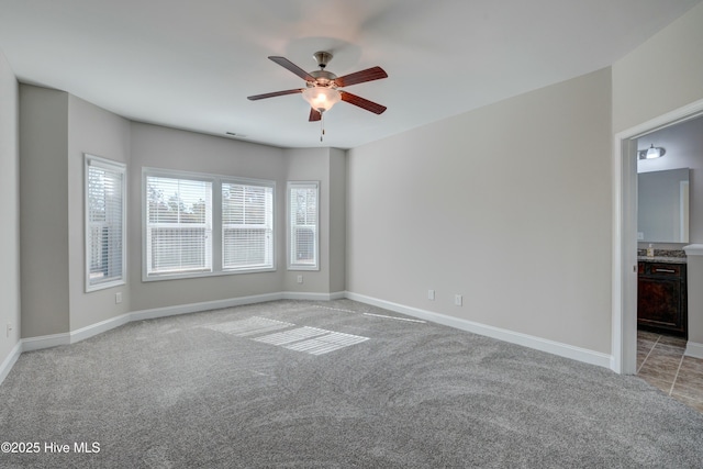 spare room with ceiling fan and light carpet