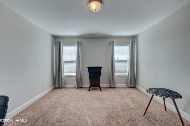 sitting room with light colored carpet and a healthy amount of sunlight