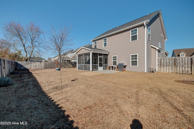 back of property featuring a patio area, a sunroom, and a lawn