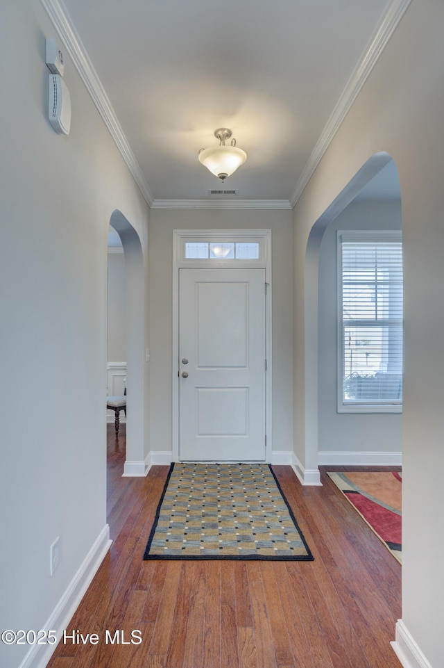 entrance foyer with crown molding and dark hardwood / wood-style floors