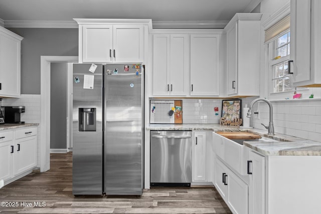 kitchen with ornamental molding, white cabinets, and appliances with stainless steel finishes