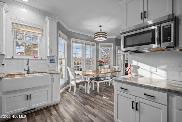 kitchen featuring white cabinetry, sink, and ornamental molding