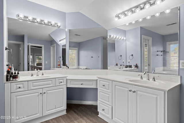 bathroom with vaulted ceiling, vanity, and hardwood / wood-style floors