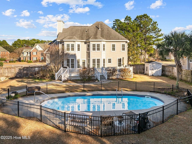 view of pool featuring a deck and a storage unit