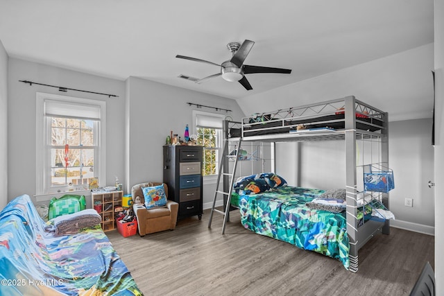 bedroom with ceiling fan, wood-type flooring, multiple windows, and lofted ceiling