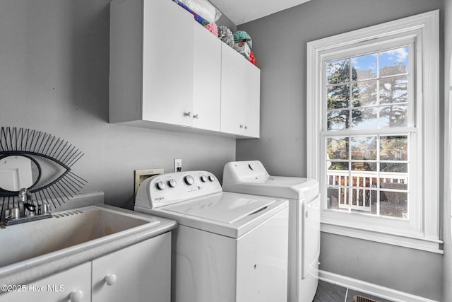 laundry room featuring cabinets, washing machine and clothes dryer, and sink