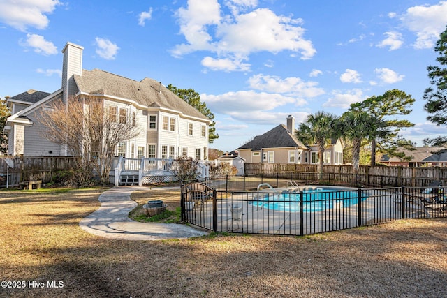 view of pool with a deck and a lawn