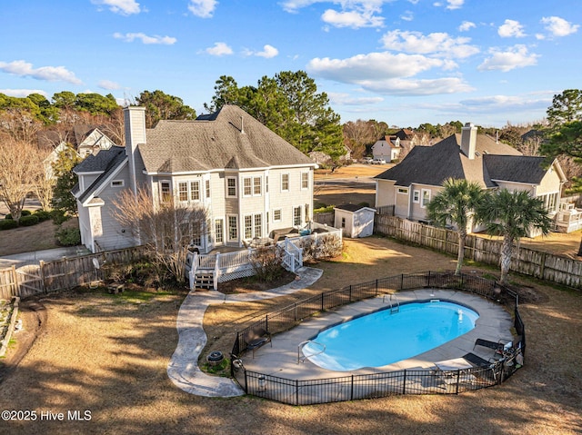 view of swimming pool with a storage unit, a yard, and a deck