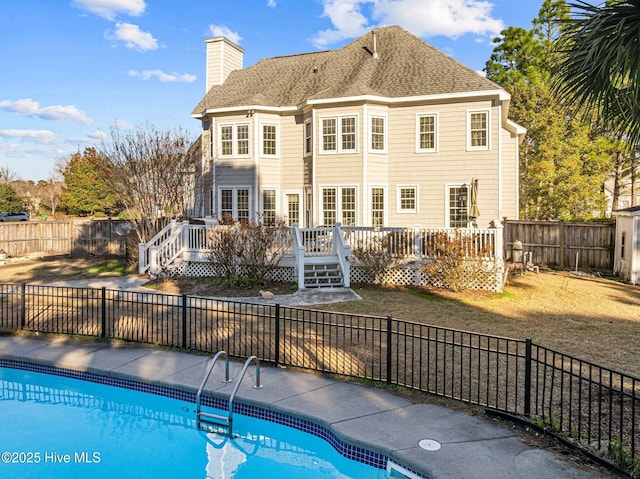 rear view of house featuring a swimming pool side deck