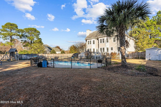 view of pool with a storage shed and a playground