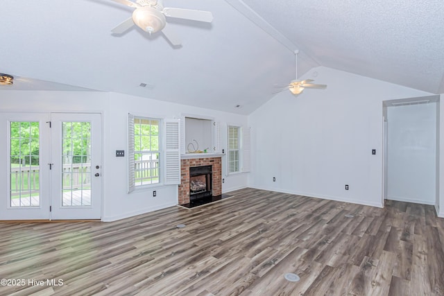 unfurnished living room with wood finished floors, a fireplace, baseboards, a ceiling fan, and lofted ceiling