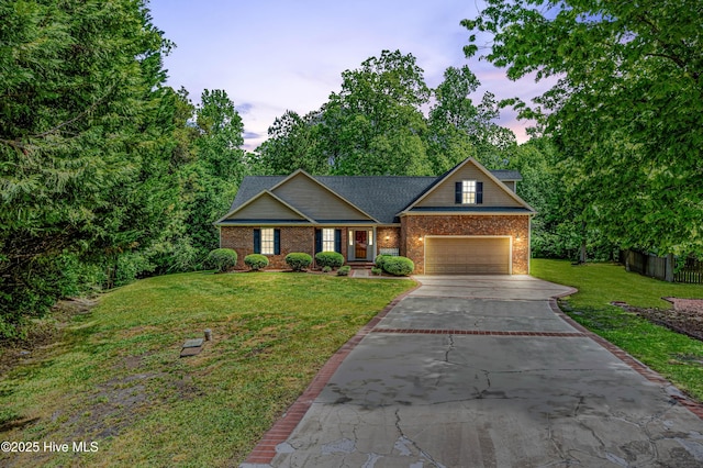 craftsman-style home with concrete driveway, fence, a yard, brick siding, and a garage