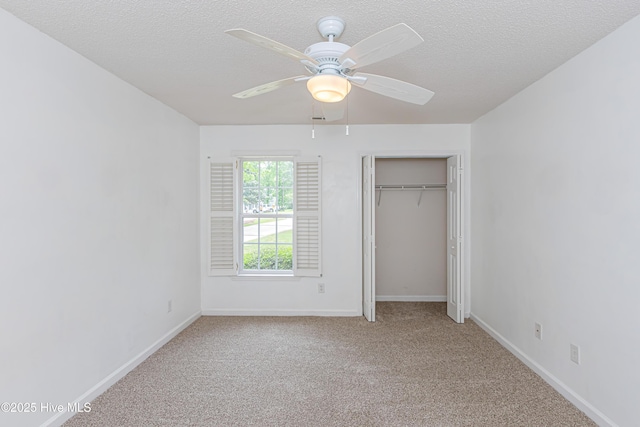 unfurnished bedroom with a textured ceiling, baseboards, and carpet floors